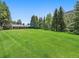 Expansive lawn in front of a single-Gathering home nestled in a wooded area at 32453 Upper Bear Creek Rd, Evergreen, CO 80439
