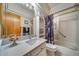 Bright bathroom featuring a shower with glass doors, marble countertops, a floral shower curtain, and ample storage at 12663 S Silver Creek Ct, Parker, CO 80134