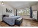 Cozy bedroom with hardwood floors, a large window view of mature trees, a mirrored wall, and charming decor at 12663 S Silver Creek Ct, Parker, CO 80134