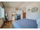Serene bedroom with hardwood floors, large window, dresser with mounted TV, and a view into a luxury bathroom at 12663 S Silver Creek Ct, Parker, CO 80134