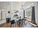 Bright dining area with modern chandelier, glass table, and large window offering abundant natural light at 12663 S Silver Creek Ct, Parker, CO 80134
