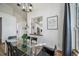 Bright dining area with modern chandelier, glass table, and view to the kitchen at 12663 S Silver Creek Ct, Parker, CO 80134