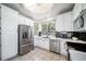 Bright kitchen featuring stainless steel appliances, white cabinets, and a black backsplash at 12663 S Silver Creek Ct, Parker, CO 80134
