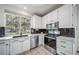 Modern kitchen with white cabinetry, stainless steel appliances, and a dark backsplash at 12663 S Silver Creek Ct, Parker, CO 80134