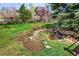 Landscaped backyard features a small water feature, rock border, foliage and trees at 6385 S Jay Way, Littleton, CO 80123