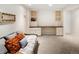 Finished basement offers built-in bookshelves and cabinets, alongside comfortable seating with vibrant pillows at 6385 S Jay Way, Littleton, CO 80123