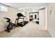 Basement with mirrored closet doors, a treadmill, stationary bike, and neutral carpet at 6385 S Jay Way, Littleton, CO 80123