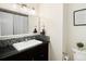 Neat bathroom boasts stylish vanity with mosaic backsplash and a framed mirror at 6385 S Jay Way, Littleton, CO 80123