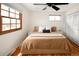 Bright bedroom with a large window, hardwood floors, and a comfortable bed with neutral bedding at 6385 S Jay Way, Littleton, CO 80123