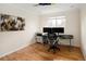 A well-lit bedroom offers hardwood floors and ample space for a home office setup at 6385 S Jay Way, Littleton, CO 80123