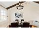 Dining room with exposed beams, chandelier, hardwood floors, and neutral paint at 6385 S Jay Way, Littleton, CO 80123