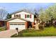 Beautiful two-story house featuring white siding, brick accents, and a well-manicured front lawn at 6385 S Jay Way, Littleton, CO 80123