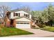 Charming two-story home with a brick chimney, attached garage, and well-maintained landscaping at 6385 S Jay Way, Littleton, CO 80123