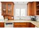Bright kitchen with granite counters, wood cabinets, stainless steel dishwasher, undermount sink, and window at 6385 S Jay Way, Littleton, CO 80123