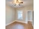 Modest bedroom featuring light walls, light laminate flooring, a ceiling fan and a large window at 575 N Marion St, Denver, CO 80218