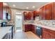 Well-appointed kitchen with dark wood cabinets, stainless steel appliances, and marble backsplash at 575 N Marion St, Denver, CO 80218