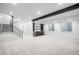 Spacious carpeted basement with a wet bar, black steel beam, and staircase with metal railings at 357 S Franklin St, Denver, CO 80209