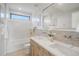 Bright bathroom with double sinks, wooden cabinets, bathtub with tile surround and chrome fixtures at 357 S Franklin St, Denver, CO 80209