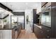 Contemporary kitchen with a center island, stainless steel appliances, custom dark cabinetry, and hardwood floors at 357 S Franklin St, Denver, CO 80209