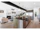 Open-concept kitchen with island seating, a modern fireplace, hardwood floors, and staircase access at 357 S Franklin St, Denver, CO 80209