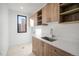 Bright laundry room features wood cabinets, a quartz countertop, and stainless steel sink under a window at 357 S Franklin St, Denver, CO 80209