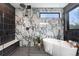 An elegant bathroom with a freestanding tub, black fixtures, and patterned marble walls at 357 S Franklin St, Denver, CO 80209