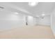 Finished basement features lots of open space and recessed lighting with neutral carpeting at 6498 S Everett Way, Littleton, CO 80123