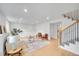Bright living room with modern decor, light wood floors, and easy access to stairs at 6498 S Everett Way, Littleton, CO 80123