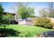Backyard features a well-maintained lawn, mature trees, a relaxing hot tub, and a privacy fence at 4360 S Braun Ct, Morrison, CO 80465