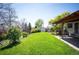 Large, well-maintained backyard with a lush lawn, storage shed, and a patio area for outdoor enjoyment at 4360 S Braun Ct, Morrison, CO 80465