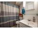 Bathroom features a shower with a stylish curtain, a sink, and modern fixtures at 4360 S Braun Ct, Morrison, CO 80465