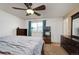 Well-lit bedroom with a ceiling fan, neutral walls, carpet floors, and a window overlooking the neighborhood at 4360 S Braun Ct, Morrison, CO 80465