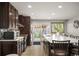 Spacious kitchen with dark wood cabinets, stainless steel appliances, island, and sliding door access to backyard at 4360 S Braun Ct, Morrison, CO 80465