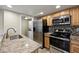 Bright kitchen with stainless steel appliances, tile backsplash and an adjacent laundry area at 8690 Allison St # H, Arvada, CO 80005
