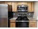 Well-equipped kitchen featuring wooden cabinets, granite countertops, and stainless steel appliances at 8690 Allison St # H, Arvada, CO 80005