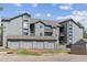 Apartment complex exterior with gray siding, garages, and well-maintained landscaping on a sunny day at 2575 S Syracuse Way # 101, Denver, CO 80231