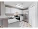 Kitchen featuring white cabinetry, stainless steel appliances, and neutral tile flooring at 2575 S Syracuse Way # 101, Denver, CO 80231