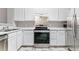 Well-lit kitchen features white cabinets, stainless steel appliances, and neutral countertops at 2575 S Syracuse Way # 101, Denver, CO 80231