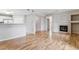 Open-concept living space with hardwood floors, fireplace, and view of the kitchen and hallway at 2575 S Syracuse Way # 101, Denver, CO 80231