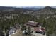 Aerial view of the property featuring a house, garage, dome structure, and surrounding wooded landscape at 29657 Loomis Way, Golden, CO 80403