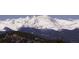 Majestic snow-capped mountains rise above lush green valleys, a picturesque landscape that captures the essence of natural beauty at 29657 Loomis Way, Golden, CO 80403