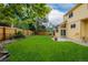 Spacious backyard featuring lush lawn, mature trees, and wood fencing for privacy and outdoor enjoyment at 12319 W Burgundy Ave, Littleton, CO 80127