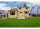 Backyard features a green lawn, patio area, and a two-story home with yellow siding at 12319 W Burgundy Ave, Littleton, CO 80127