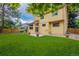 Open backyard featuring green lawn, wood fencing, patio, and the yellow siding of the house at 12319 W Burgundy Ave, Littleton, CO 80127