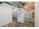 Unfinished basement with open space, shelving, concrete flooring, and refrigerator, offering potential for customization at 12319 W Burgundy Ave, Littleton, CO 80127