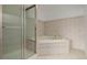 Bathroom showcases a shower with a glass door and a tiled tub, blending functionality with style at 12319 W Burgundy Ave, Littleton, CO 80127