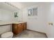 Bright bathroom featuring a vanity with wood cabinets, tile flooring, and a large mirror with vanity lighting at 12319 W Burgundy Ave, Littleton, CO 80127