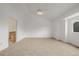 Open bedroom layout with neutral carpet and a window with natural light, adjacent to a bathroom area at 12319 W Burgundy Ave, Littleton, CO 80127