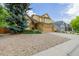 Charming two-story home with a well-maintained lawn, mature trees, and a spacious driveway at 12319 W Burgundy Ave, Littleton, CO 80127
