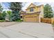 Two-story home featuring a front-facing two-car garage, brick and shingle siding, and lush landscaping at 12319 W Burgundy Ave, Littleton, CO 80127